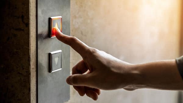 fear-of-elevators person pushing an elevator button to overcome fear of elevators